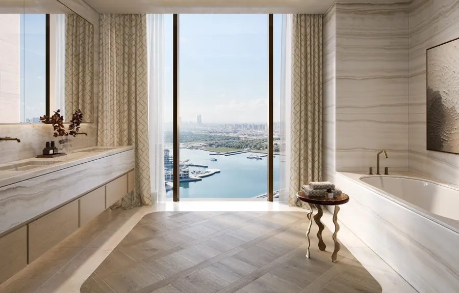 Freestanding bath framed by a window over the waterfront