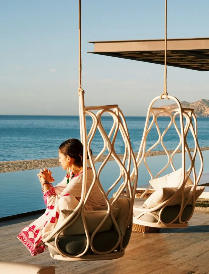 Relaxing in a woven hanging chair above the sea